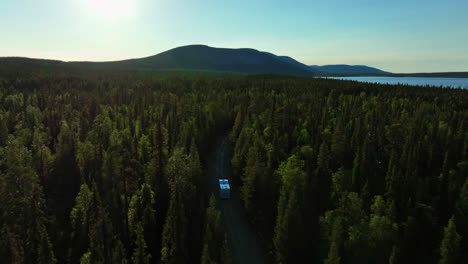 Aerial-view-following-a-RV-driving-at-a-arctic-lake-in-wilderness-of-the-north