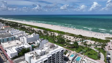 Aerial-establishing-shot-of-Sandy-beach-of-Miami-with-palm-trees-with-seascape