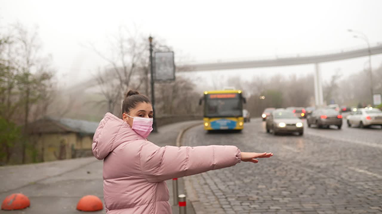 안개가 많은 도시 날씨에서 버스를 기다리는 여자