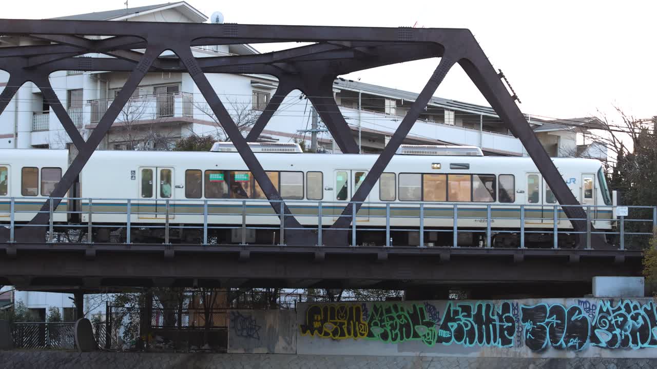 열차가 도시 그래피티가 있는 다리를 지나간다.