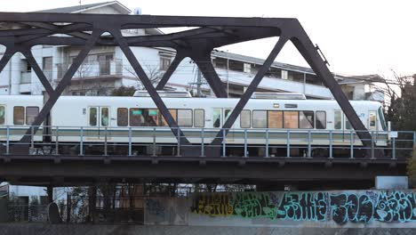 a train passes over a bridge with urban graffiti.