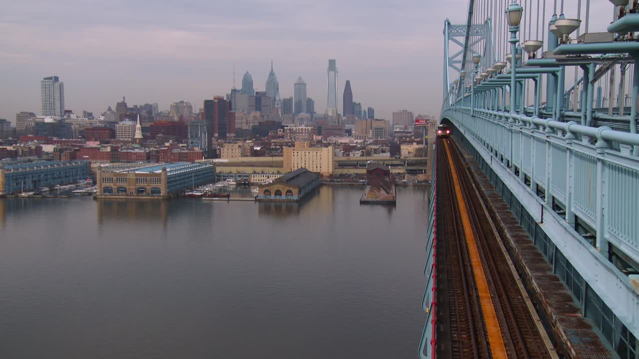 통근열차가 필라델피아 펜실바니아를 배경으로 벤 프랭클린 다리를 건넌다