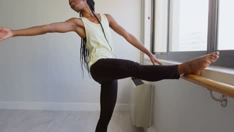 woman stretching on barre near window 4k