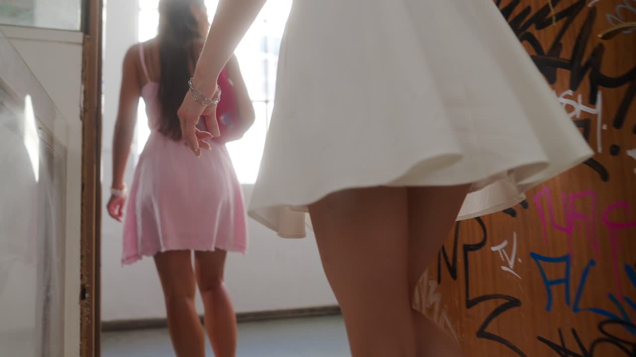 Two women in dresses walking down stairs