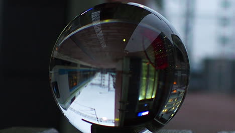 Crystal-ball-reflects-a-passing-train-at-station