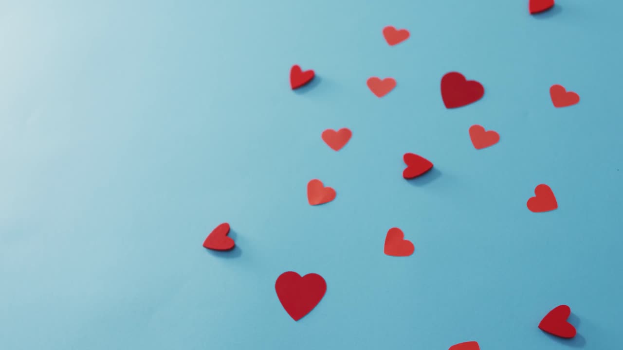Multiple red paper hearts at valentine's day on blue background