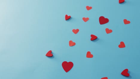 múltiples corazones de papel rojo en el día de san valentín sobre un fondo azul