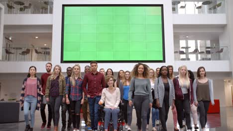 large group of students walk to camera in university atrium