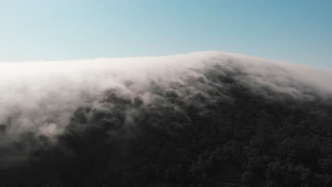 aerial moves to an amazing lenticular cloud formation blanketing the mountain of monte de santa tecla galicia, spain