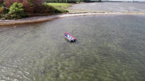 drones vuelan alrededor de una pequeña lancha anclada frente a la costa