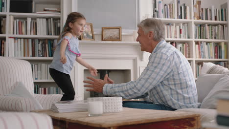 cute-little-girl-hugging-grandfather-playfully-jumping-into-grandad's-arms-having-fun-enjoying-weekend-with-grandparent-at-home