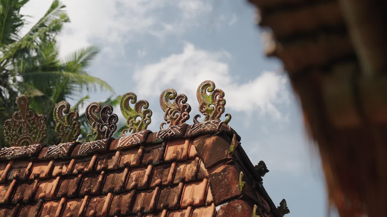 Balinese roof with a blue sky and clouds in the background