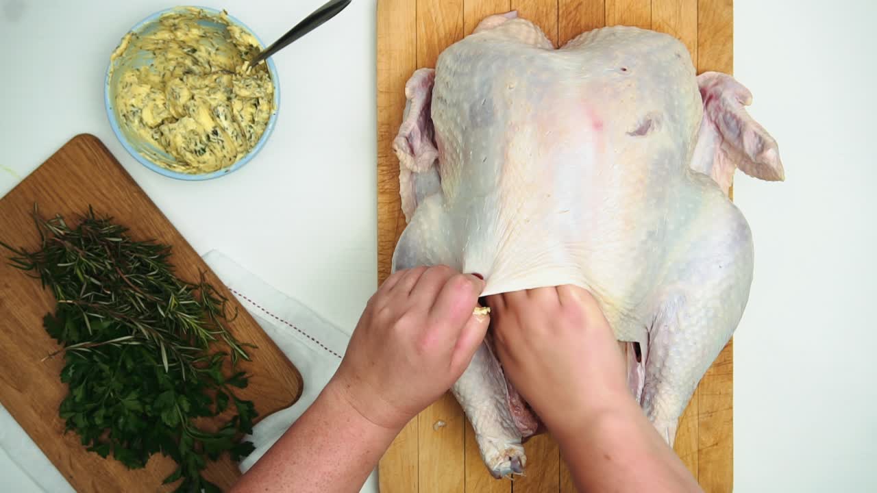 Stuffing Fresh Whole Turkey With Rosemary And Cilantro Herb Butter - overhead shot