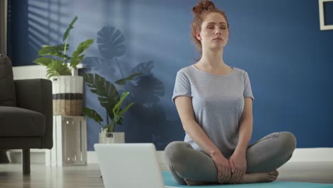 video of woman meditating at home on exercise mat