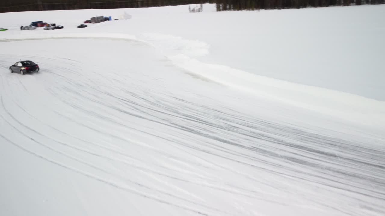 Two Sport Cars Drifting on Frozen Lake in Finland – Aerial Winter Landscape with a frozen race track low altitude follow shot