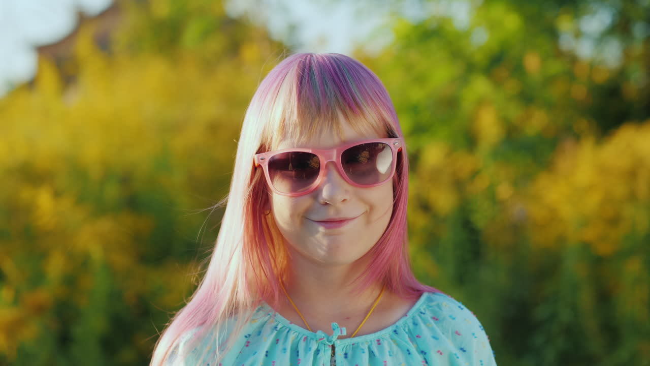 retrato de una chica con el pelo rosa con gafas de sol rosas