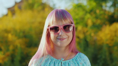 retrato de una chica con el pelo rosa con gafas de sol rosas