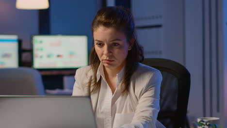 business woman working overtime to respect deadline of project sitting in business office