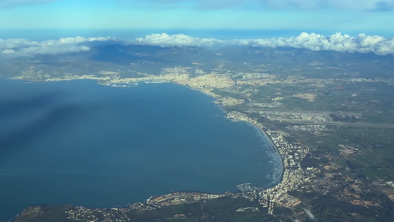 Vista da cabine da Baía de Palma de Maiorca, com uma vista aérea lateral da cidade e do aeroporto em uma tarde ensolarada.