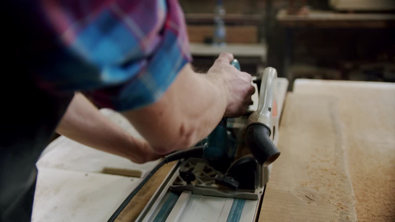 cámara lenta. el maestro corta una tabla de madera con una sierra circular en el taller de carpintería de un pequeño fabricante de muebles. v3