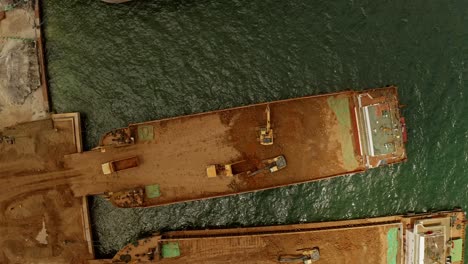 dump trucks and excavators loading nickel ore onto barges at a sumitomo mining site in taganito philippines