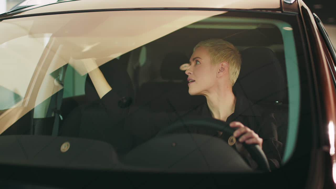 여자 는 자동차 에서 거울 과  비저 를 조정 하고 있다