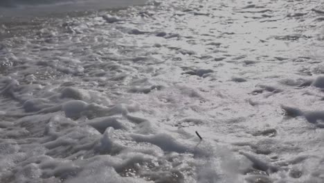 shot of the shore of the beautiful juan dolio beach at sunset, waves moving on the warm sand, beautiful detail in slow motion