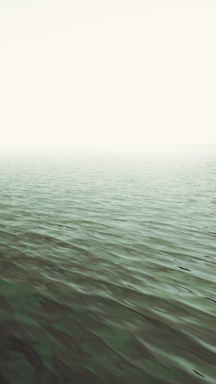 Calm waters reflect cloudy sky near distant shoreline during morning light