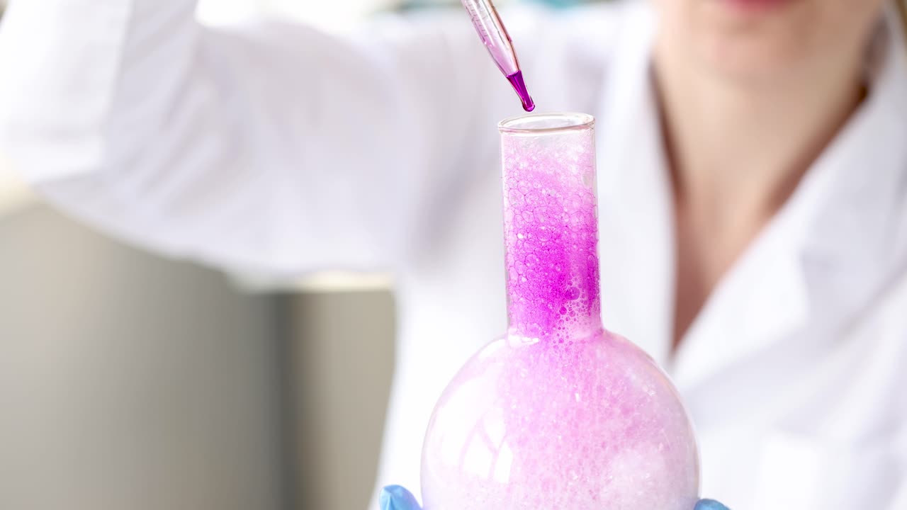 Scienziato chimico che pipetta liquido in soluzione schiumogena, filmato 4k