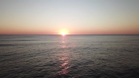 imágenes aéreas estáticas de una puesta de sol distante en la playa con un océano tranquilo, costa rica