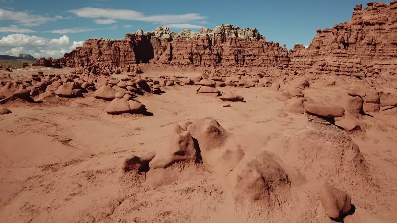 Volo sopra strane formazioni rocciose di arenaria nel Parco Statale di Goblin Valley, Utah USA, drammatica ripresa aerea in risalita