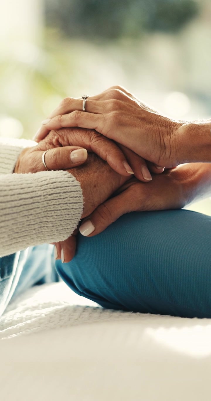 Primer plano de manos entrelazadas en señal de consuelo y apoyo