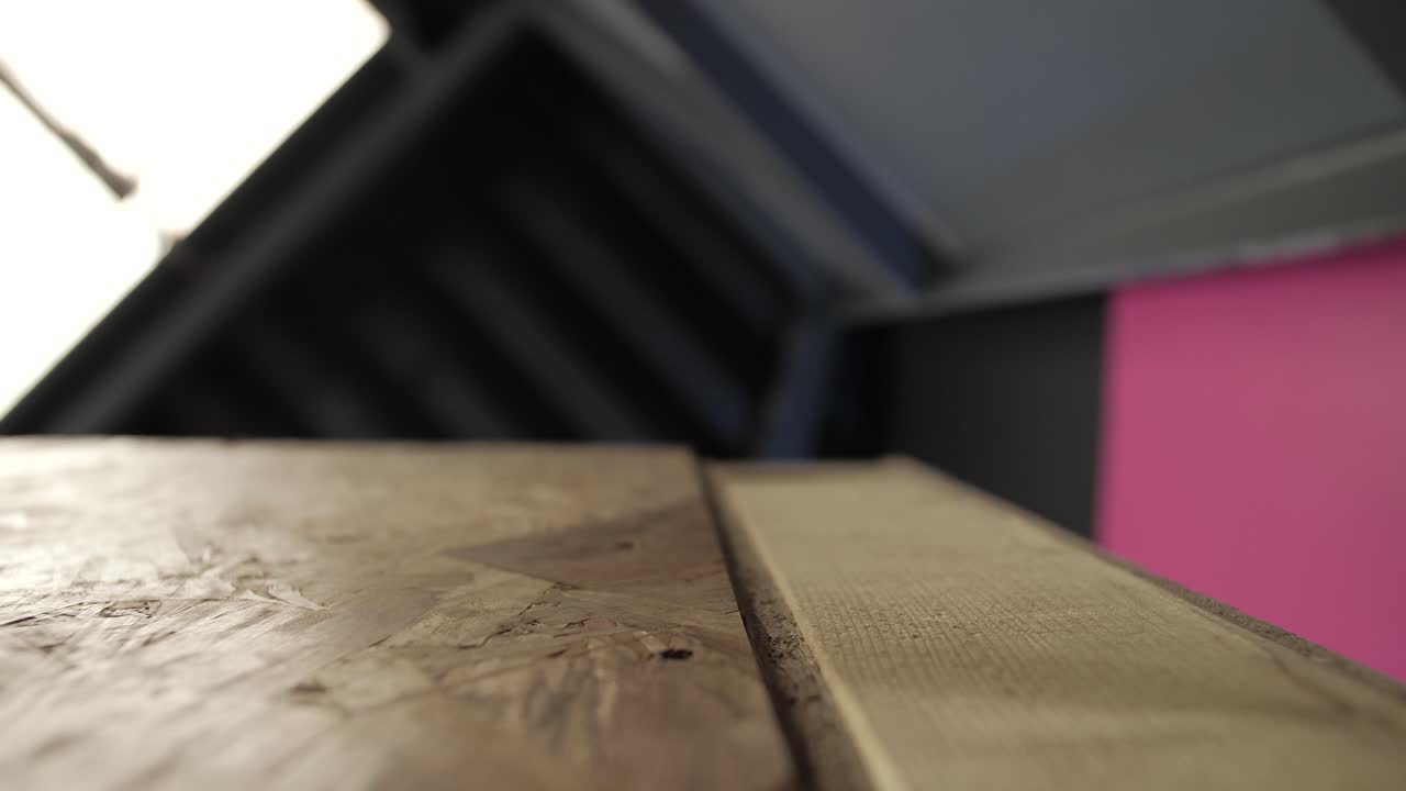 Close-up of OSB wood table surface with visible grain and a slight crack