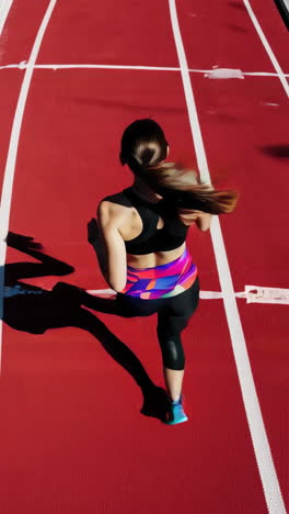 female athlete running on a red track