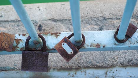 close view of love padlocks on a bridge with nice depth of field, in the background a river