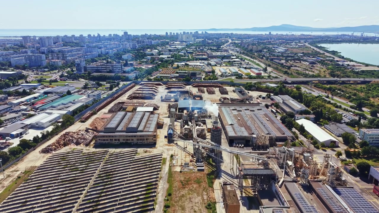 Aerial view of an industrial area with factories and solar panels in the background during a sunny day