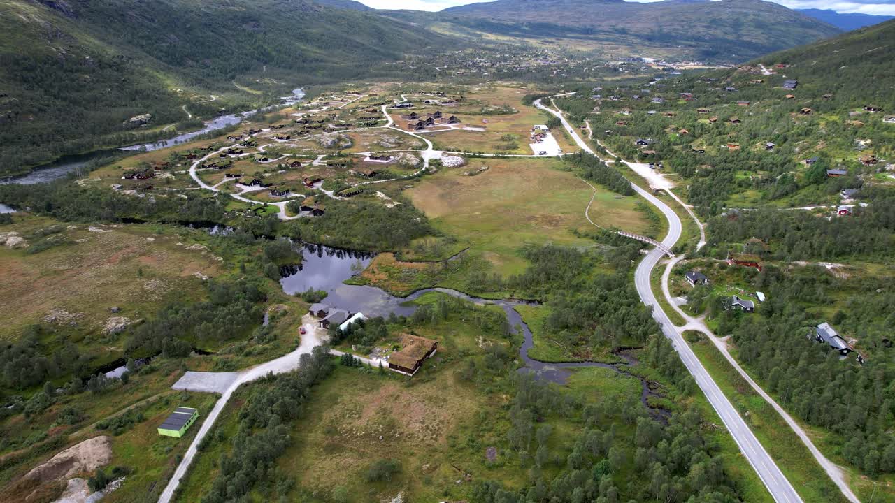 Hytter og vejbyggeri ved Maurset Hardangervidda Norge, der viser arealanvendelse i en bjergdal.