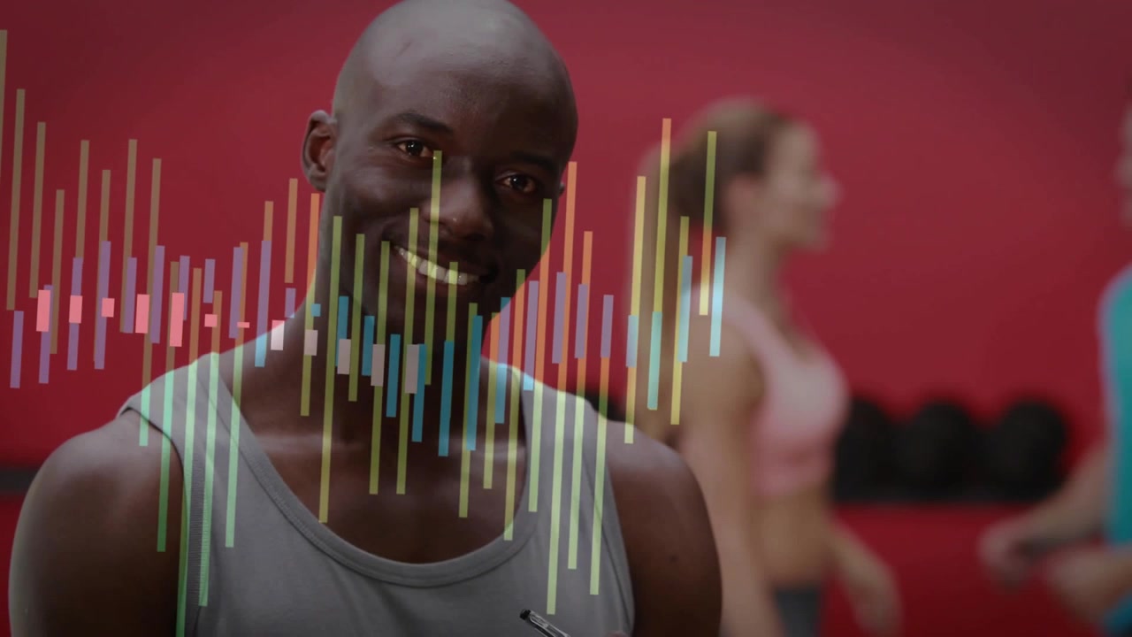Kamera panorerer, mens træner skriver på udklipsblok, kigger op og peger, mens stænger strækker sig over fitnesscenteret og engagerer brugere
