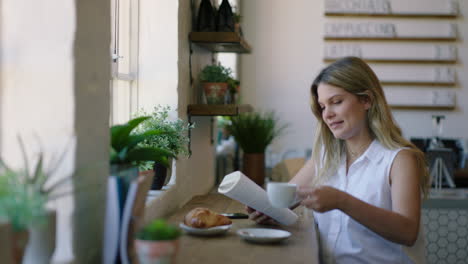 Schöne-Frau,-Die-Im-Café-Ein-Buch-Liest,-Kaffee-Trinkt-Und-Ein-Entspanntes-Morgenfrühstück-In-Einem-Trendigen-Restaurant-Genießt,-Das-Glücklich-Lächelt