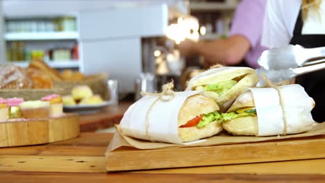 waitress arranging sandwiches on counter