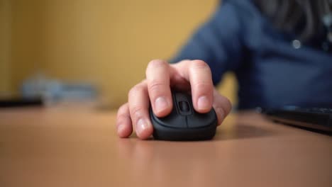 woman using laptop at home holding mouse clicking