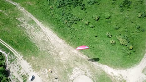 paragliding in the mountains. green fields, hills