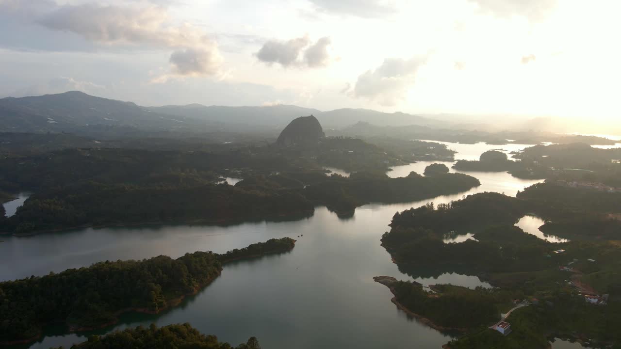Aerial of scenic nature landscape of Guatape with the world famous rock Peñon during beautiful cloudy sunrise.