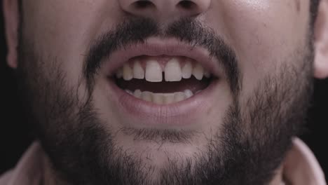 close up of a man's mouth talking and smiling with slight tooth gap and full beard