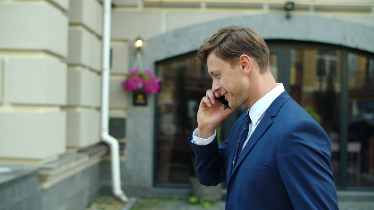 성공적 인 사업가 가 밖 에서 휴대 전화 로 사업 프로젝트 를 논의 하고 있다