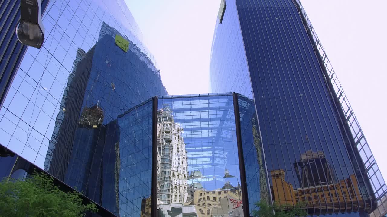 отражения на стеклянных офисных зданиях. камера наклоняется к небу.