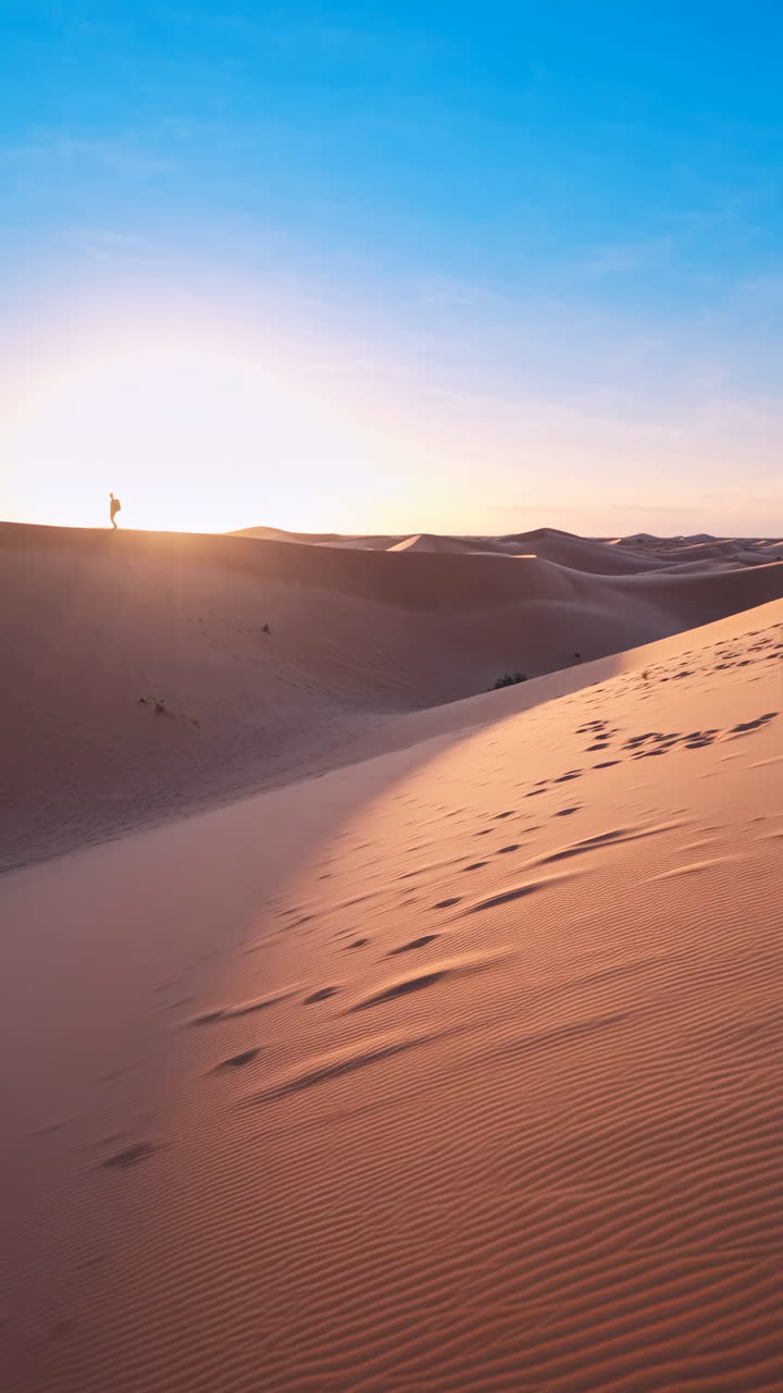 Lone Traveler on Desert Dunes at Sunset