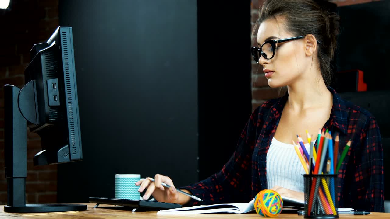 una chica hermosa trabajando con una computadora.