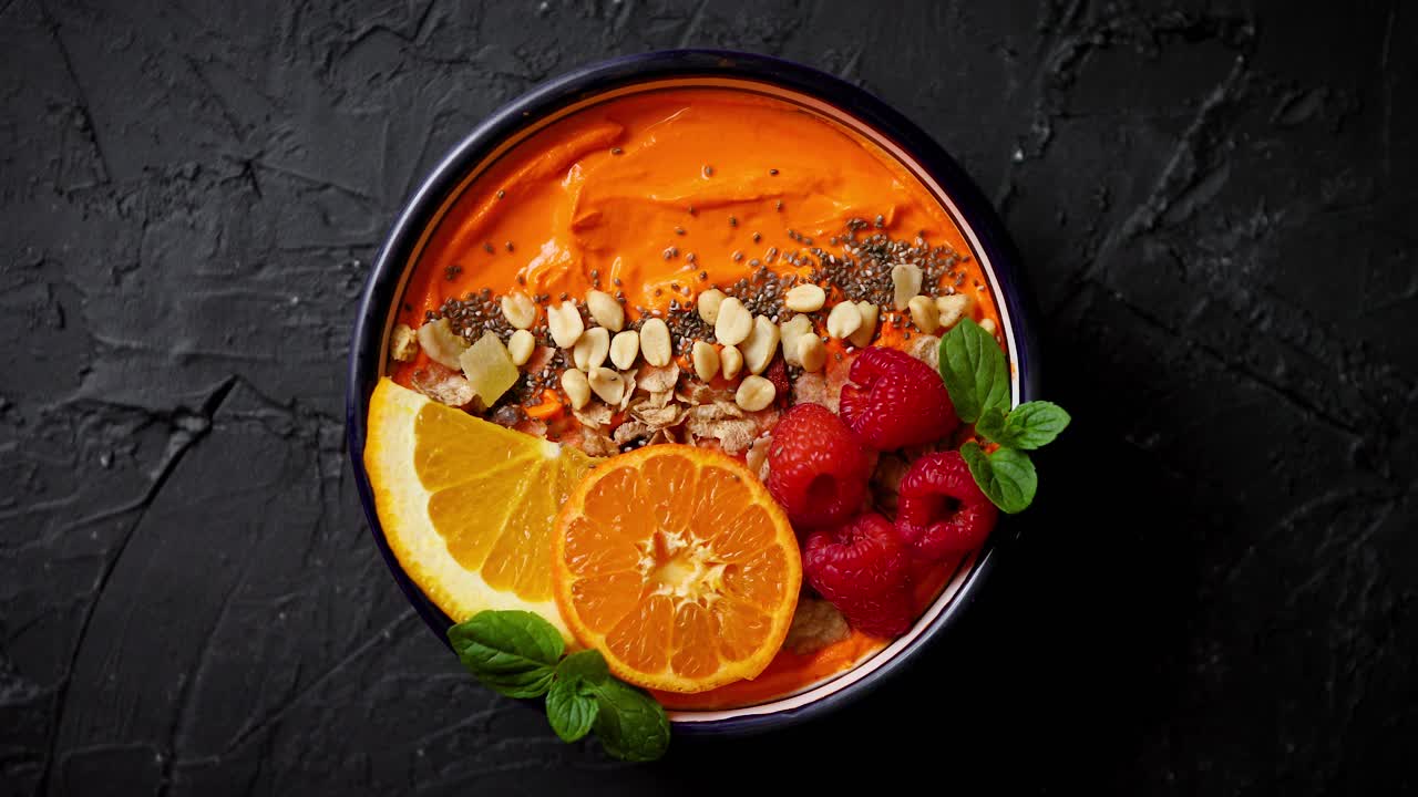 Mangkuk dengan smoothie atau yoghurt segar dan sehat Dengan irisan jeruk, jeruk keprok, raspberry, chia, dan kacang-kacangan