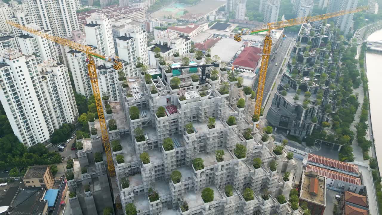 중국 상하이의 수저우 크리크 (suzhou creek) 주변 건물과 운하와 함께 건설 중인 미래의 1000개의 나무 쇼핑 센터 위를 날아다니는 드론 촬영